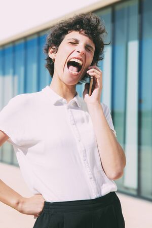 Excited woman talking by mobile phone outdoor. Happy middle aged businesswoman talking by smartphone...