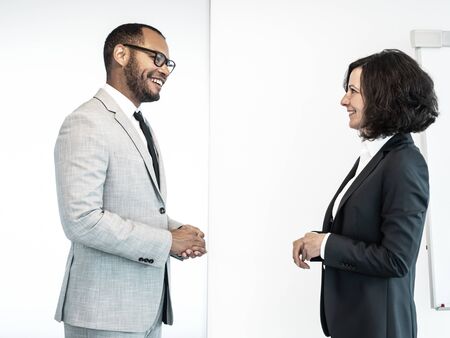 Two friendly confident professionals discussing business issues in conference room. Business man and...