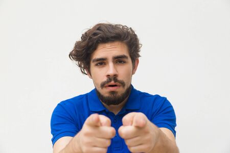 Front view of bearded man pointing to camera with forefingers. Studio shot of handsome stylish guy gesturing. Choosing you conceptの写真素材
