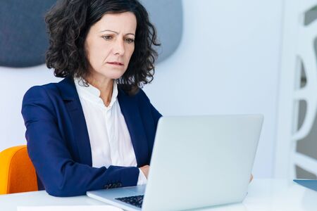 Confused frowning businesswoman getting concerning news. Business woman sitting at white conference...