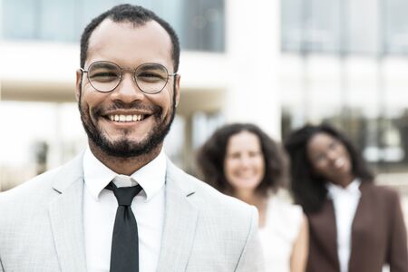 Happy confident business leader outside. Young Latin businessman in glasses, office suit and tie...