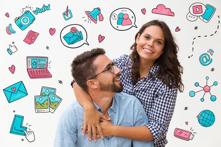 Sweet couple having fun with hand drawn social media sketches. Pair hugging and posing. Young woman...