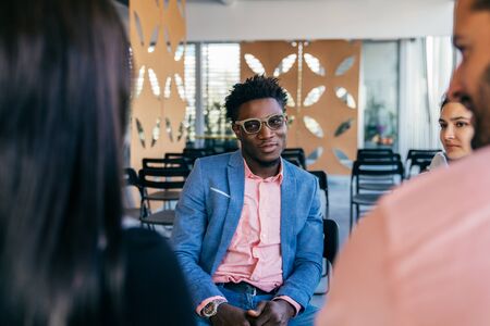 Stylish African American entrepreneur discussing project with colleagues. Young business men and...