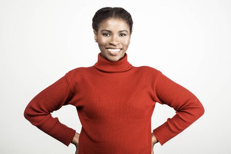 Smiling young woman holding hands on hips. Cheerful African American lady looking at camera. Female beauty conceptの写真素材