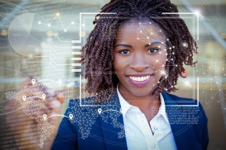 Woman drawing on glass board and virtual identification graphics. Young African American businesswoman using pen, writing, looking at camera, smiling. Drawing on board conceptの写真素材