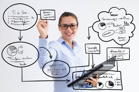 Smiling young woman holding file and drawing virtual management flowcharts. Pretty business lady giving lecture. Presentation concept. Isolated front view on white background.の写真素材