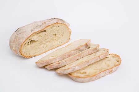Cut fresh wheat bread part and slices. Closeup shot. Isolated object on white background. Homemade...