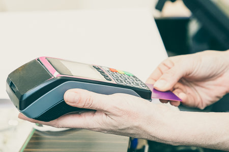Shop cashier operating payment process and inserting credit card in pos terminal. Cropped shot,...