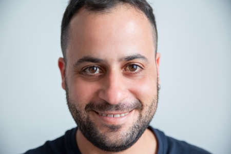 Close-up of smiling man looking at camera. Happy Caucasian man isolated on gray background and posing. Close-up of smiling man conceptの写真素材