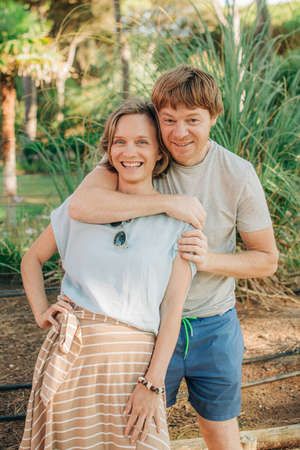Portrait of happy couple posing together outdoors. Mid adult man embracing his smiling wife. Love and relationship conceptの写真素材