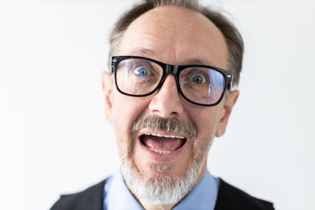 Close-up of excited mature businessman wearing eyeglasses. Senior Caucasian manager looking at camera with open mouth. Eyesight and admiration conceptの写真素材