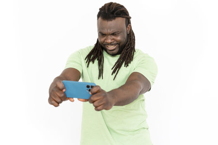 Confused African American man looking at mobile phone screen. Serious man having online video call...
