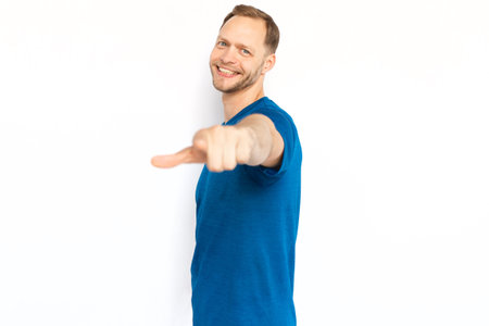 Happy Caucasian man pointing index finger at camera. Smiling bearded man looking at camera on white background, motivating, choosing you or encouraging. Confidence, choice conceptの写真素材