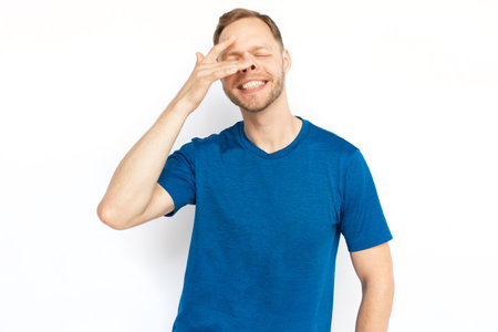 Caucasian man fooling at camera on white background. Happy male adult having fun with finger on his nose, playing tricks and posing for camera. Fun, happiness conceptの写真素材