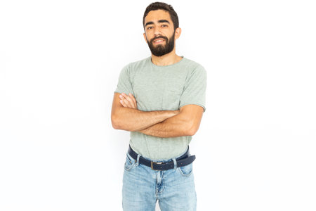 Confident man with crossed arms. Young male model standing looking at camera with confidence. Portrait, studio shot, confidence conceptの写真素材
