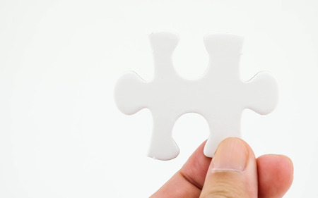 Jigsaw puzzle in hand isolated on white background for businessの写真素材
