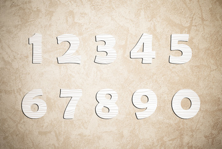 White wooden numbers on cement wall background, zero to nineの写真素材