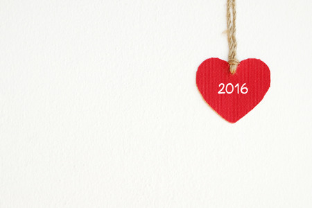Red fabric heart with 2016 word hanging on the clothesline, new year template