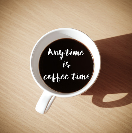 Any time is coffee time : Quote with coffee cup on wood background, top viewの写真素材