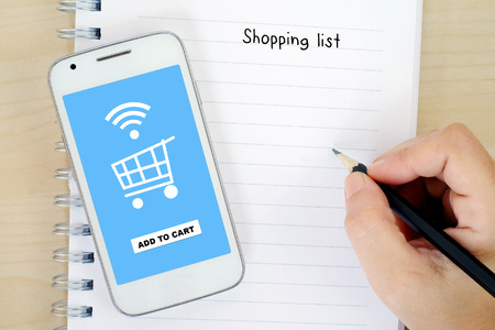 Smart phone with shopping online on screen and shopping list background, business and technology conceptの写真素材