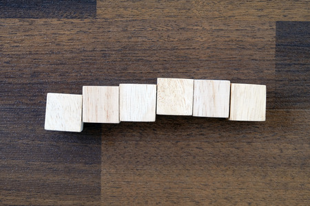 Wooden cubes on wood background, top view