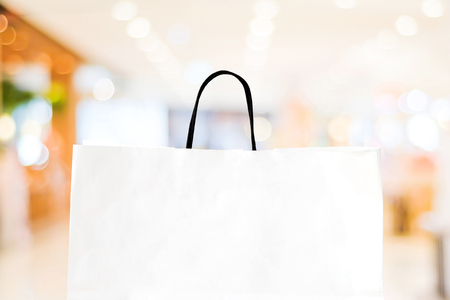 White shopping bag over blurred store background, business, template, retail, saleの写真素材