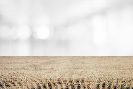 Empty table and sack tablecloth over blur abstract bokeh light background, product display montage,...