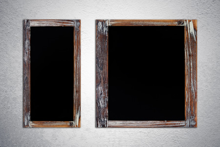 Blank vintage chalk boards on grunge cement wall backgroundの写真素材