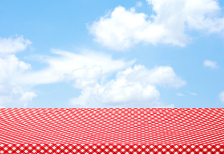 Empty red table cloth over blue sky background, food and product display montageの写真素材