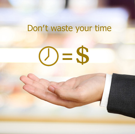 Time is money icon over businessman hand, don't waste your time conceptの写真素材