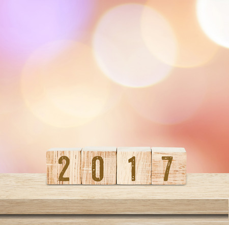 Wooden cubes with 2017 on table over blur bokeh background, new year templateの写真素材
