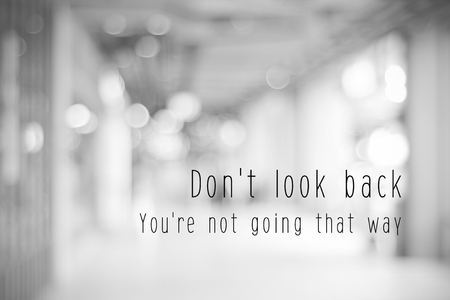 Don't look back, you're not going that way, life quotation on blur abstract black and white bokeh light backgroundの写真素材