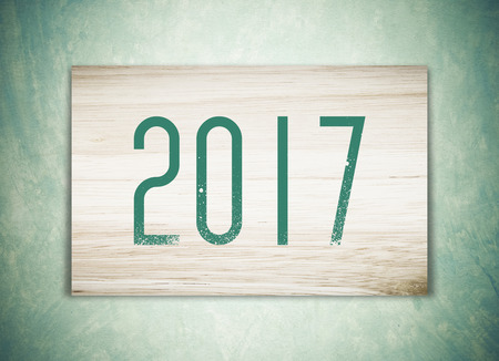 2017 on wood over green vintage cement wall background, new year and christmas greeting seasonの写真素材