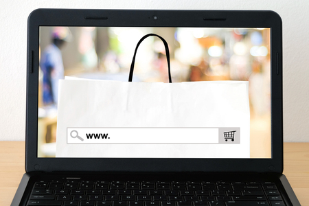 Lab top with www. on search bar over blur store background on screen, on line shopping ,business, E-commerce, technology and digital marketing backgroundの写真素材
