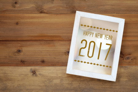 Happy new year 2017 on white vintage wooden frame on wood background with copy spaceの写真素材