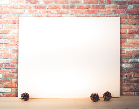 Blank white poster over brick wall background, vintage filtered, template, mock upの写真素材