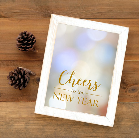 Cheers to new year with copy spce on white vintage wooden frame on wood backgroundの写真素材