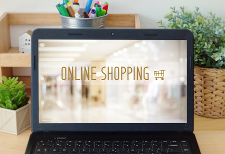 Laptop with shopping online device over blur store background on screen, business and technology concept, digital marketingの写真素材