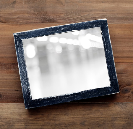 Blur festive bokeh on black wooden frame on wood background, template, flat lay, top view