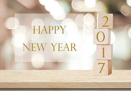 Wooden cubes with 2017 and happy new year over blur bokeh background, new year banner