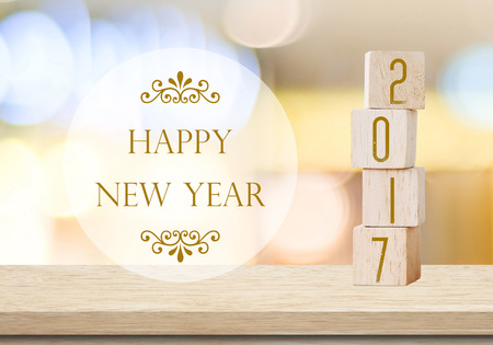 Wooden cubes with 2017 and happy new year over blur bokeh background, new year banner
