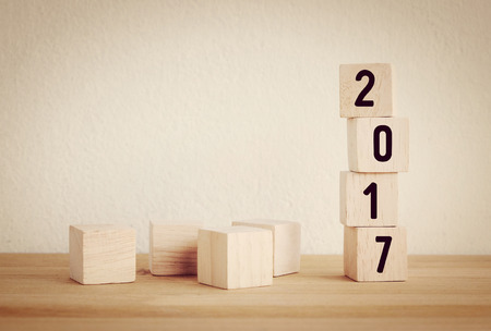 Wooden cubes with 2017 on wooden table background, new year template, vintage filteredの写真素材