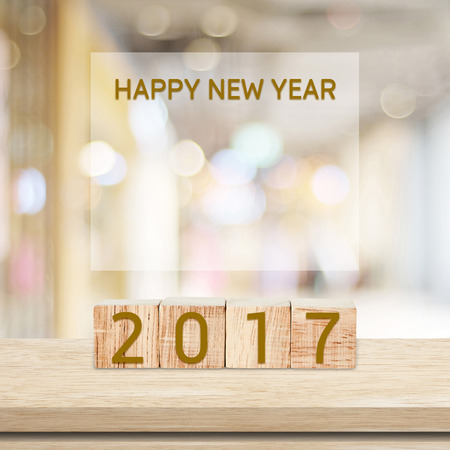 Wooden cubes with 2017 and happy new year over blur bokeh background with copy space for text, new...