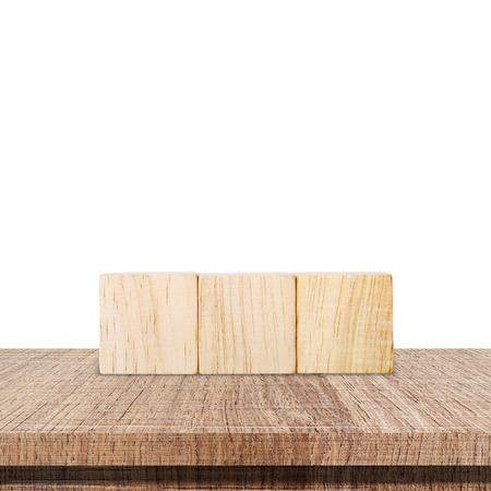Three wooden cubes on wood table isolated on white backgroundの写真素材