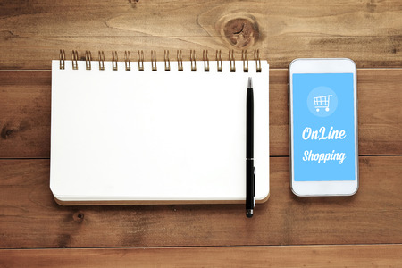 Smart phone with shopping online on screen and blank note book backgroundの写真素材