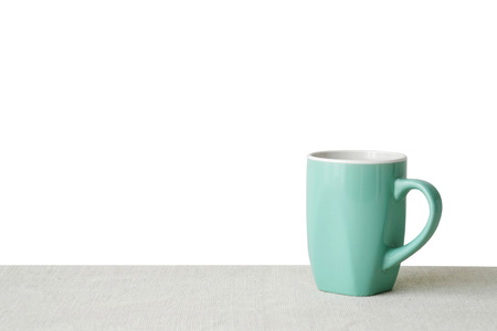 Green coffee cup on sack tablecloth isolated on white background, with copy space for text , product display montageの写真素材
