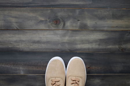 Brown leather sneakers on vintage wood background, top view with copy space for text and product...