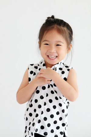 Cute little asian girl smiling in white bedroom background, happy expression emotionの写真素材