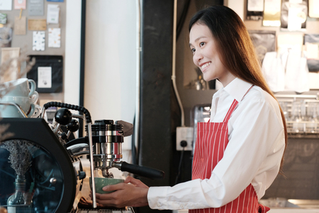 Young asian women Barista using coffee machine at counter in her cafe background, small business owner, food and drink industry conceptの写真素材