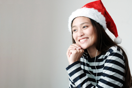 Cute asian girl wearing Christmas hat with smiling face, Merry Christmas and happy new year conceptの写真素材